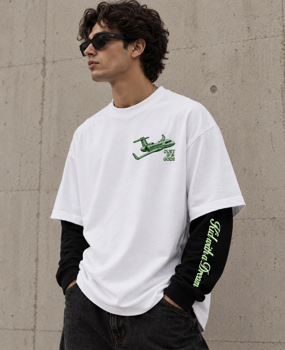 Kid with a Dream Oversized Doctor Sleeve Unisex T-Shirt by DUSTOFGODS, white oversized tee with green airplane chest graphic shown from the front at an angle.
